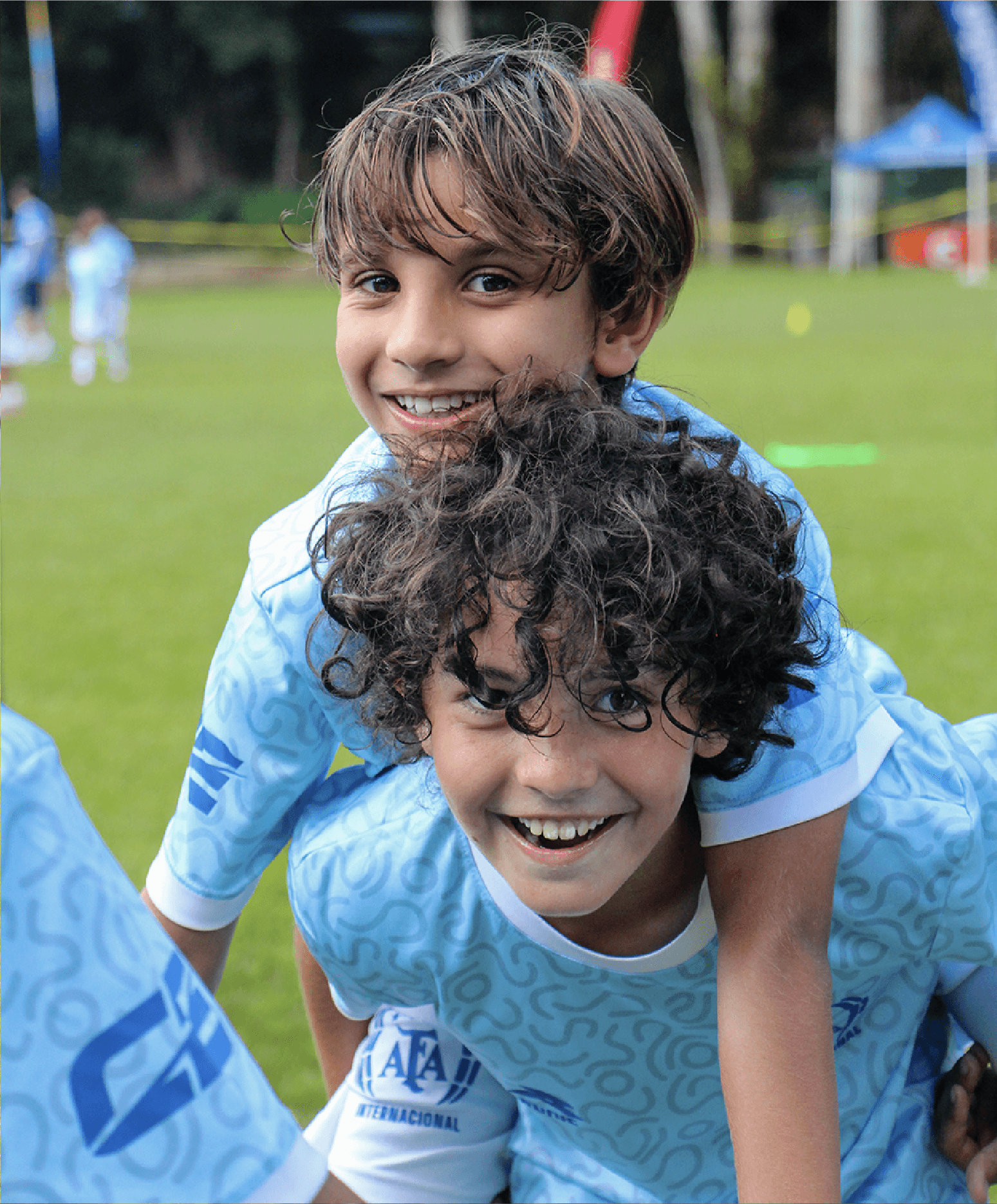 Dos campistas sonriendo entre ellos durante una actividad en la cancha